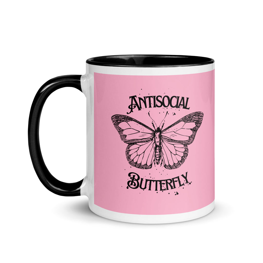 Pink and black ceramic mug with black gothic style text reading “Antisocial Butterfly,” perfect for introverts or gothic coffee lovers.